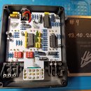 V černé plastové krabičce je umístěna elektronická deska s komponenty, včetně integrovaných obvodů a odporů. Na desce je nápis CHORUS a grafický symb…