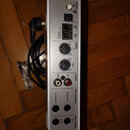 Stříbrný audio rozhraní s řadou konektorů na zadní straně. Jsou zde nápisy power, bus powered firewire, MIDI in a out, s/pdif DI a DO, line outputs c…