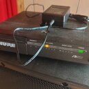 Černý bezdrátový přijímač s nápisem SHURE a označením SCA RECEIVER. Na předním panelu jsou kontrolky DIVERSITY (A, B), RF LEVEL (1–5) a AUDIO LEVEL (…