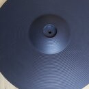 Černý gumový pad elektronického činely s koncentrickým žebrováním. V horní části je vyražený nápis Roland. Povrch vypadá čistý a v dobrém stavu.