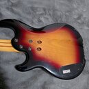 Zadní strana elektrické kytary s lakovaným povrchem v červeno-žlutém přechodu (sunburst). Na spodní části těla je nalepený štítek s nápisy: YAMAHA, C…
