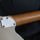 Detail spoje krku a těla kytary v béžové barvě. Na kovovém krytu spoje je vyryto logo Godin a nápis Made in Canada. Krk nástroje je vyroben z hladkéh…