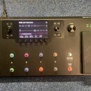 Černý kytarový procesor s nápisem HELIX LT a logem LINE 6. Zařízení má digitální displej, ovládací knoflíky a čtyři řady spínacích tlačítek označenýc…