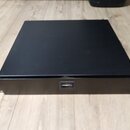 Černý kovový rackový šasi s obdélníkovým tvarem. Na předním panelu je uprostřed umístěn jeden USB port. Povrch je matně černý a bez viditelných znače…