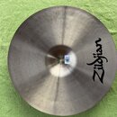Kruhové činely z kovu s viditelným broušením povrchu. Na pravé straně je černé logo Zildjian. U středu se nachází malý bílý štítek s nečitelným texte…