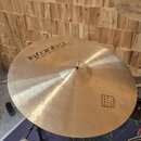 Zlatavý činely s viditelným broušením povrchu. Na ploše je černý nápis istanbul Agop Handmade Cymbals from Turkey a v pravé dolní části čtvercový rám…