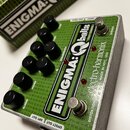 Zelený efekt pedál s nápisem ENIGMA:Qballs for Bass a značkou electro-harmonix MADE IN NYC, USA. Zařízení má osmi černých otočných knoflíků a dva sto…