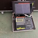 Digitální mixovací pult v transportním kufru s připojeným monitorem značky ASUS. Na ovládacím panelu je vidět nápis DIGITECH a řada posuvníků, tlačít…