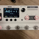 Bílý efektový procesor Hotone Ampero II Stage. Na horní straně jsou nápisy AMPERO II STAGE, Hotone a popis CCDM HD Gen 2 Amp Modeler / Effects Proces…
