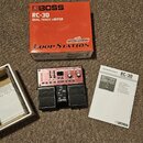 Na fotografii je loop station Boss RC-30 v červeném provedení s černými pedály. K zařízení patří původní oranťová krabice s nápisy BOSS RC-30 DUAL TR…