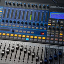 Digitální mixovací pult PreSonus STUDIOLIVE 16.0.2 USB v šedé barvě. Zařízení obsahuje řadu posuvníků, tlačítek a otočných ovladačů s modrými detaily…