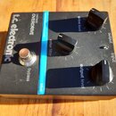 Černý kytarový efekt s nápisy t.c. electronic a VINTAGE OVERDRIVE. Na horní straně jsou tři černé otočné ovnovací knoflíky s popisky drive level, col…