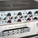 Stříbrný rackový procesor s černým horním krytem, umístěný na kartónovém balení. Na předním panelu je nápis PORTICO II Master Buss Processor a v prav…