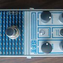 Kytarový efekt pedál v kovovém šasi s modro-černým pruhovaným designem. Na levé straně je nápis catalinbread MECHANISMS OF MUSIC a vpravo označení SF…