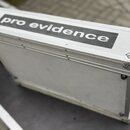 Stříbrný transportní kufr z hliníku s kovovými hranami a vrchním víkem. Na horní straně je černý nápis pro evidence v bílém rámečku. Kufr vykazuje dr…