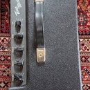 Kytarový zesilovač v černém texturovaném potahu s kovovou rukojetí. Na ovládacím panelu je nápis Tone Master® FR-212 a pět otočných potenciometrů s p…