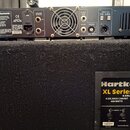 Zadní strana basového komba značky Hartke. Horní část tvoří zesilovač s nápisem Hartke Systems, který obsahuje ventilátor a různé konektory označené…