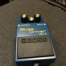 Modrý kytarový efekt s nápisem Blues Driver BD-2 a logem BOSS na černém spínacím pedálu. Na horní straně jsou tři zlaté ovládací knoflíky a dva vstup…