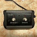 Černý efektový pedál s šedým rámem a dvěma stoupavými spínači. Na černé ploše jsou bílé nápisy CH SELECT a EFFECTS, logo Fender a text FENDER MUSICAL…