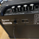 Černý kytarový zesilovač s ovládacími knoflíky a přepínači. Na horním panelu je nápis IBZ2G GUITAR AMPLIFIER a popisy ovládacích prvků VOLUME, TREBLE…