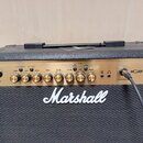 Kytarové kombo s černým povrchem a zlatým ovládacím panelem. Na přední straně je bílé logo Marshall a označení modelu MG30FX. Panel obsahuje několik…