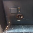 Detail zadní strany černého přístroje s napájecím konektorem. Je zde uveden nápis MADE IN ITALY a specifikace Mains 220Vac 50 Hz. Povrch vykazuje zná…