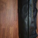 Černý pol pevný pouzdro na hudební nástroj s žlutým detailem. Na boku je vidět nápis ROCKBAG. Povrch má svislé rýhy a několik čtvercových protiskluzo…