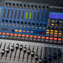 Digitální mixážní pult s nápisem STUDIOLIVE 16.0.2 USB a logem PreSonus. Zařízení má modré ovládací prvky, řadu posuvníků a digitální displej s texte…