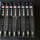 Černý kontrolér s osmi posuvníky a ovládacími tlačítky. Na přístroji je bílý nápis X-TOUCH EXTENDER a logo behringer. Nad posuvníky se nacházejí řady…