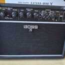Černý kytarový kombo zesilovač značky BOSS s modelem KATANA-MINI X. Horní ovládací panel obsahuje knoflíky pro Gain, Type, Volume a Equalizer (Bass,…