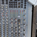 Šedý míchací pult s nápisem SPIRIT By Soundcraft a LIVE 24. Horní panel obsahuje různé vstupy, výjupy a konektory XLR, z nichž některé jsou označeny…