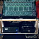Na fotce je vidět monitor značky Iiyama, na kterém je zobrazeno rozhraní pro ovládání zvukového mixu s názvem Rack 1. Monitor je umístěn na hliníkové…
