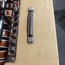 Kytarový zesilovač s béžovým textilním potahem a koženou rukojetí. Na horním ovládacím panelu jsou černé otočné knoflíky s nápisy TREBLE, MIDDLE a BA…