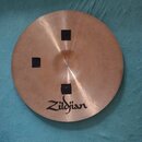 Kulatý činely z měděného kovu s viditelným broušením povrchu. Na spodní části je čitelné logo Zildjian. V horní, levé a spodní části jsou nalepeny tř…