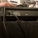 Zadní strana černého kytarového komba s texturovaným povrchem. Na zadním štítku je uveden nápis MAX POWER 40W, Made in Korea a varovné texty s označe…