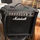 Kytarový kombo zesilovač značky Marshall, model MG15CFX. Má černý povrch s karbonovou texturou a stříbrný ovládací panel s několika otočnými knoflíky…