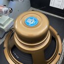 Zlatý reproduktor s kovovým rámem a magnetem. Na modré štítku je uveden nápis CELESTION LOUDSPEAKERS, ALNICO G10 Gr14 a CELESTION INTERNATIONAL LTD E…