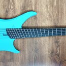 Světle modrá elektrická basová kytara s černým hmatníkem a dvěma černými humbuckery. Na těle nástroje je viditelné bílé logo tvořené třemi malými kro…