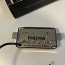 Kytarový humbucker snímač v kovovém rámečku s černým vinutím. Na krytu je černý nápis FRIEDMAN a pod ním menší text CLASSIC PLUS HUM - BRIDGE. Povrch…
