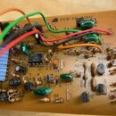 Fotografie zachycuje detail tiskемого spoje (PCB) s elektronickými součástkami a zapojením barevných vodičů. Na desce je viditelný nápis PCB-TS-0101…