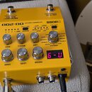 Žlutý kytarový efekt BOSS OD-200 HYBRID DRIVE. Na horní straně jsou dva spínací pedály, pět ovládacích knoflíků a červeně svítící digitální displej s…