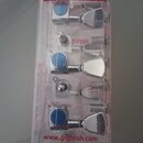 Sada ladících mechanismů v plastovém obalu s červeným nápisem Machine Heads. Mechanizmy jsou chromované s modrými knoflíky a na spodní části obalu je…
