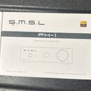 Bílá papírová krabice s černým pruhem uprostřed. Na krabici jsou nápisy S.M.S.L, PH-1 a MM PHONO AMPLIFIER, v pravém horním rohu je oranžový štítek H…