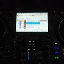 Černý DJ mixážní systém s dvěma jogovými koly. Na přístroji jsou nápisy Numark a MIXSTREAM PRO GO. Uprostřed se nachází zapnutý displej zobrazující h…