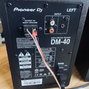 Zadní strana černého studiového monitoru s nápisem Pioneer DJ a označením LEFT. Na zadním panelu je vstup INPUT se dvěma kanály, výstup OUTPUT TO RIG…