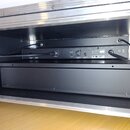 V otevřeném transportním case jsou umístěna dvě černé rackové zařízení. Horní jednotka má na zadní straně nápisy ANTENNA A, ANTENNA B a USB BALANCED…