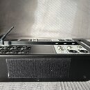 Černý elektronický přístroj s řadou vstupních konektorů. Na horní hraně je nápis INPUTS a vedle něj jsou viditelné značky 1, 2, 3, 4 a 5 u jednotlivý…