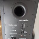 Zadní strana černého studiového monitoru s nápisem Model: T8V a sériovým číslem 17M23020997. Na zadním panelu je logo a nápis ADAM AUDIO Berlin, Germ…
