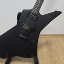 Černá elektrická kytara s matným povrchem a hranatým, asymetrickým tvarem těla. Nástroj má dva humbuckery a jeden ovládací knoflík. Na kytáře nejsou…