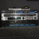 Sada rackového audio vybavení v černém a stříbrném provedení. Z horní části jsou viditelné zařízení s nápisy lexicon MPX 101 Dual Channel Processor,…